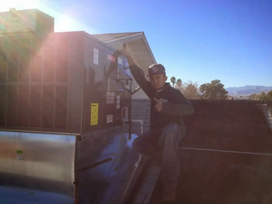 HVAC technician performing Boiler Repair on a rooftop unit in Keller